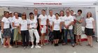 Das Team des Selbsthilfezentrum München steht gemeinsam vor einem Pavillon. Jedes Teammitglied trägt ein weißes SHZ-T-Shirt