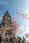 Viele bunte Luftballons steigen vor dem Rathaus in München in den blauen und wolkenlosen Himmel.